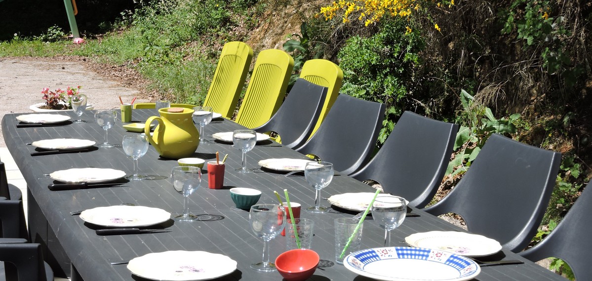 Grande table dressée en plein air pour un repas de groupe au Moulin du Barthas